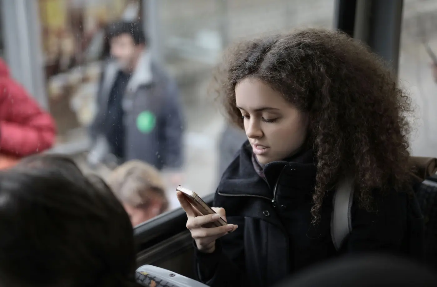 Pasajera revisando el celular dentro de un bus